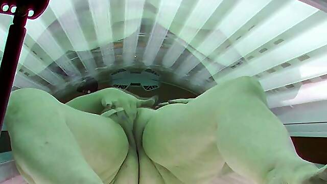 Busty MILF masturbates in solarium